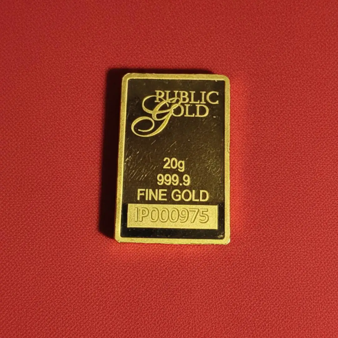 Batangan emas Public Gold 20g 999.9 dengan nomor seri pada latar belakang merah